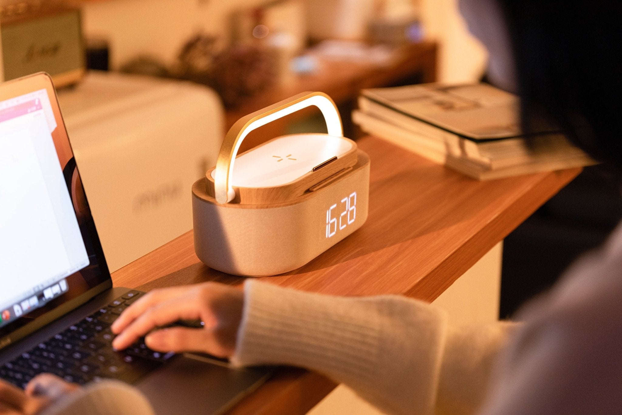 UK Technology Clock Radio Handle Lamp on a desk next to a person working on a laptop