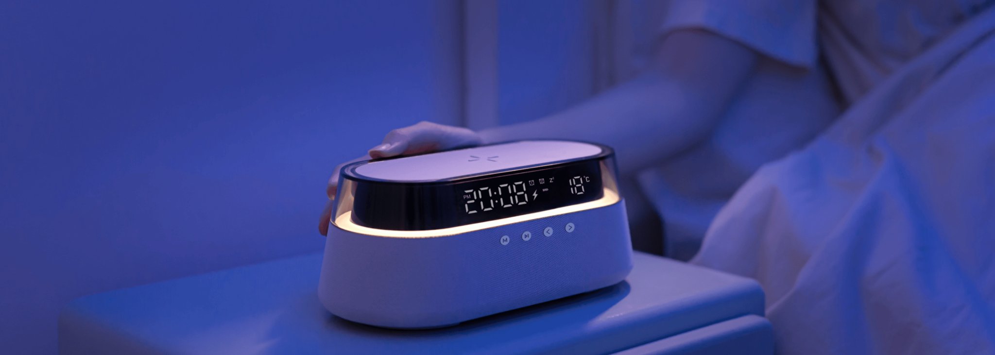 UK Technology radio alarm clock glass top on a bedside table at nighttime