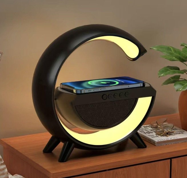 UK Technology G Lamp Wireless Charger Speaker black close up on a bedside table with a yellow light displayed